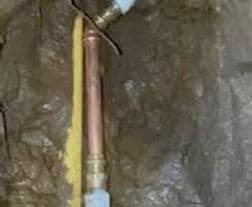 Copper plumbing pipe installed in a concrete wall, showcasing plumbing work details.
