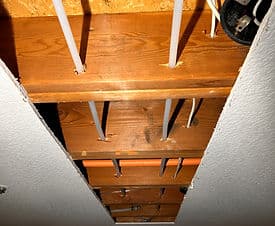 View of exposed ceiling joists with plumbing and electrical lines in a home renovation.