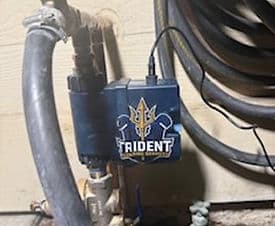 Trident valve control system installed on a pipe, featuring logo and wiring details.