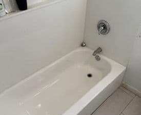 Clean, modern bathtub with faucet in a bright bathroom setting.