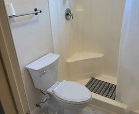 Bathroom featuring a shower stall and a white toilet with a modern design.
