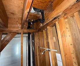 Exposed wooden beams and plumbing in a home renovation project.